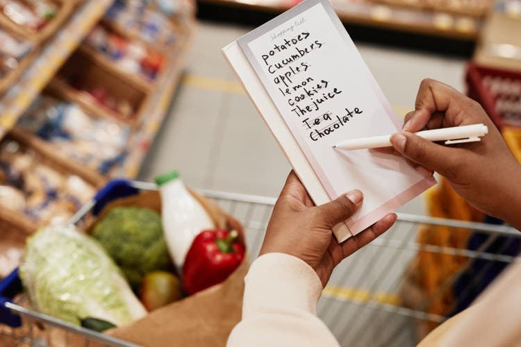 Woman Crossing Items of Shopping List