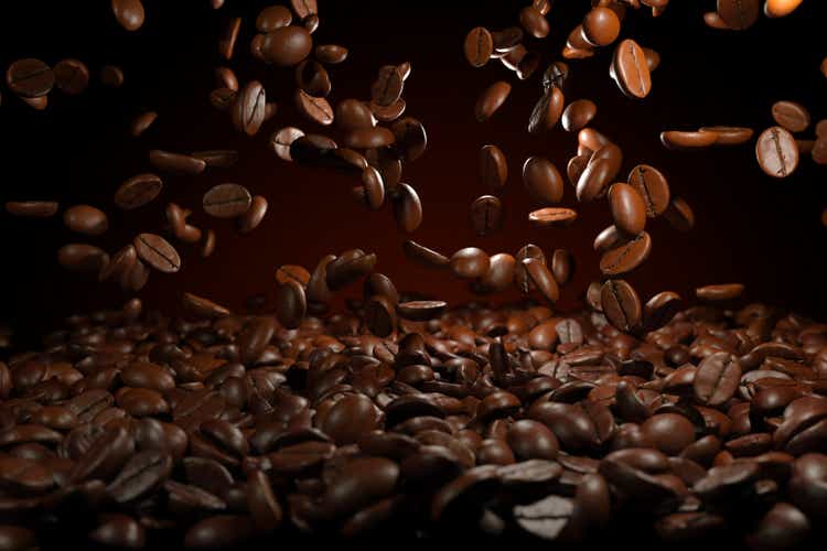 Falling roasted coffee beans on brown background