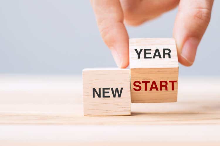 hand flip wooden block with New Year to New Start text on table background. Resolution, strategy, solution, goal, business and holiday concepts