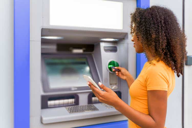 One black woman withdrawing money at an atm