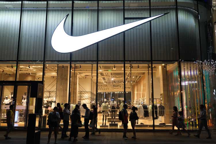 Large NIKE store at night with many people's silhouette