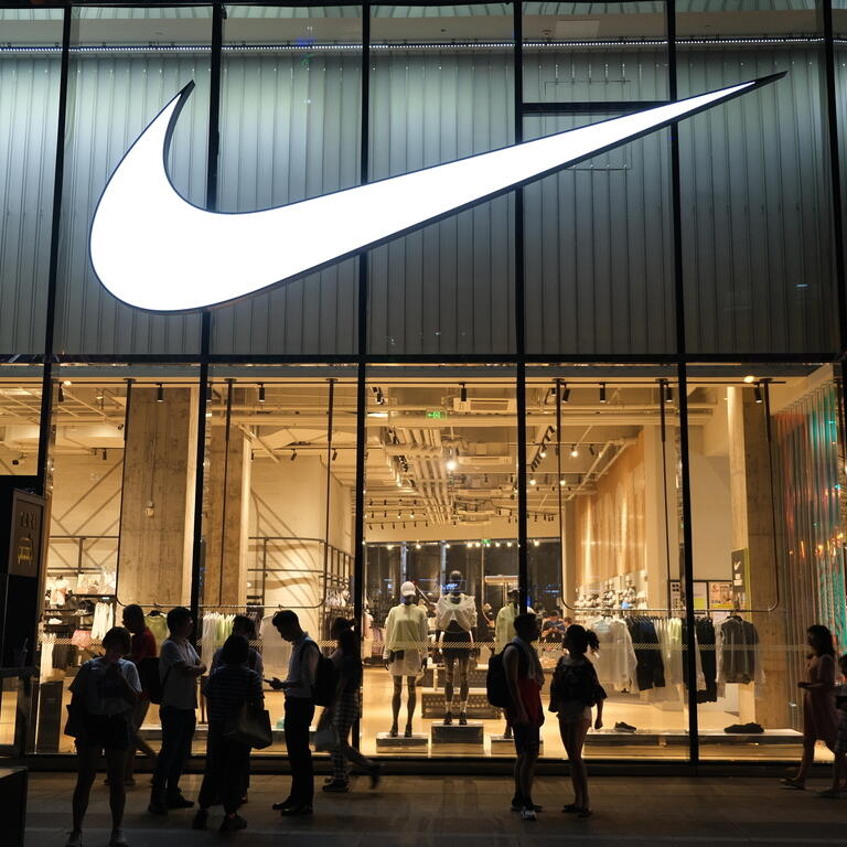 Large NIKE store at night with many people