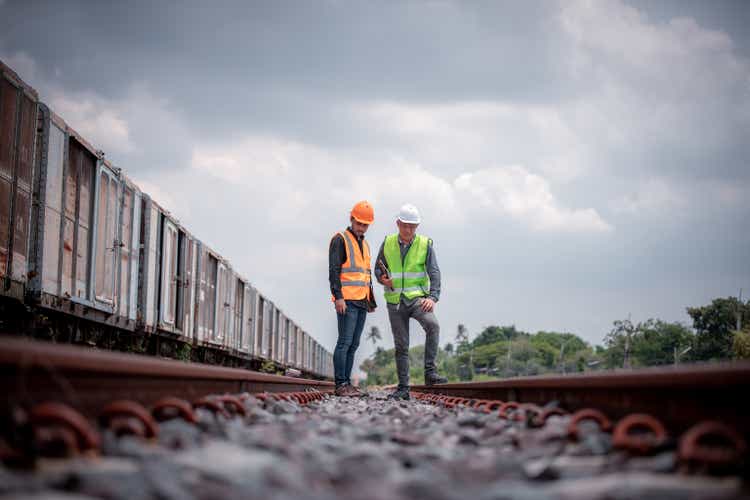 Engineer under discussion inspection and checking construction process railway switch and checking work on railroad station .Engineer wearing safety uniform and safety helmet in work.