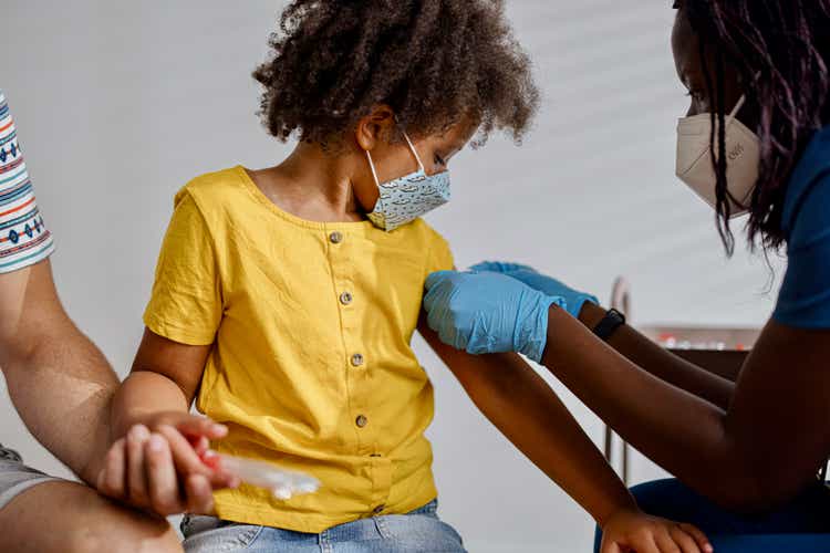 Little girl taking a vaccine from her doctor, pediatrist