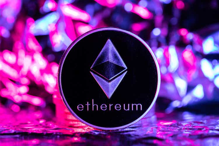 Kriptovaluta Ethereum, fizički novčić ispred apstraktne pozadine