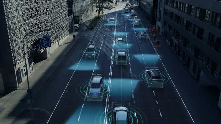 Aerial Drone Shot: Autonomous Self Driving Cars Moving Through City. Concept: Artificial Intelligence Scans Surrounding Environment, Detecting Cars, Pedestrians, Avoids Traffic Jams and Drives Safely.