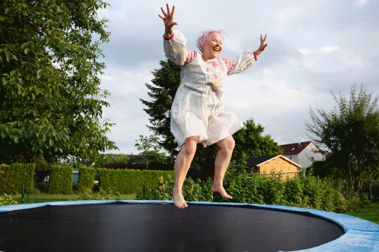 Senior woman with overweight jumping on trampoline