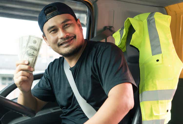 happy smiling Asian men truck driver holding banknote US dollar.