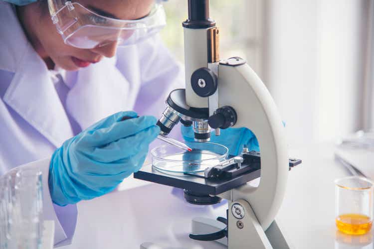 Woman scientist in lab look at science microscope medical test and research biology chemistry. Females technician laboratory analyzing scientific pharmacy genetic research. Chemistry Medical test lab