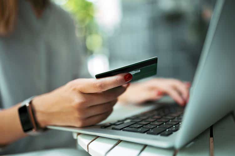 Young woman with credit card and laptop