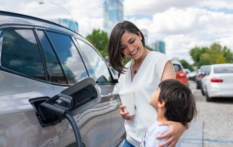 Woman And Child Charging Electric Car