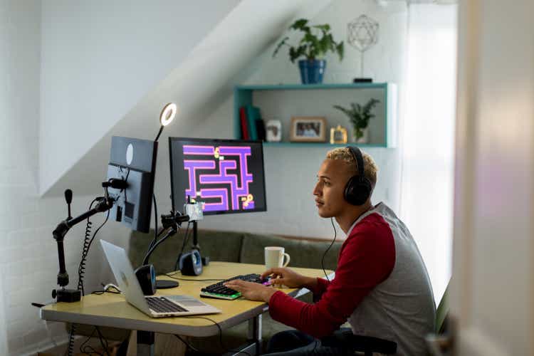 Young mixed race gamer playing online in his bedroom