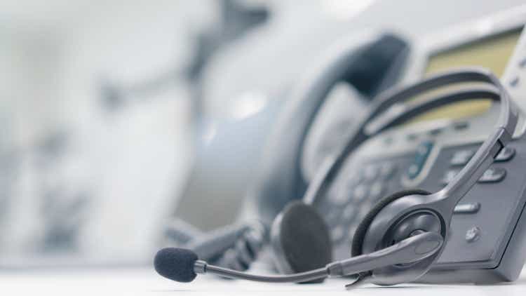 close up headset of call center and VOIP for communication technology on office table in monitoring room for network operation job concept