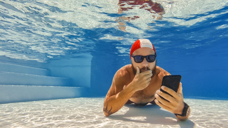 Funny man selfie with mobile phone underwater: extreme telecommuting