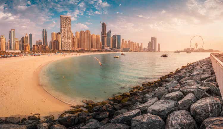 Panoramic view of the golden sand illuminated by the setting sun in the JBR beach area. Amazing skyscrapers and warm waters of the Persian Gulf are waiting for guests and tourists