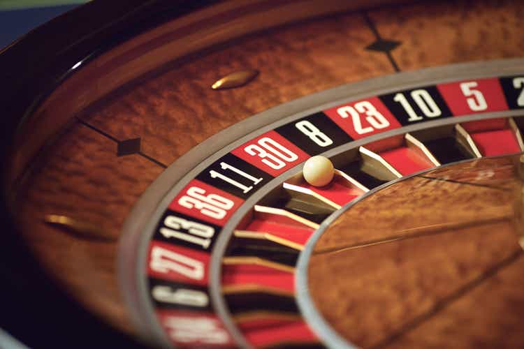 Close up roulette wheel white ball at zero in casino