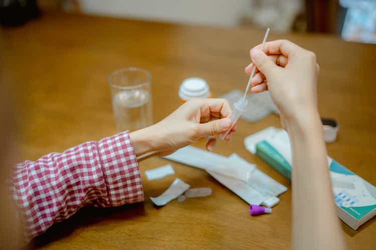 Young woman drops swab in a protective plastic tube.