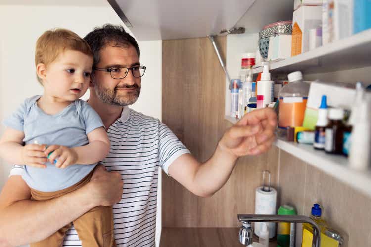 Dad and his baby son taking medicines out of the medicine cabinet