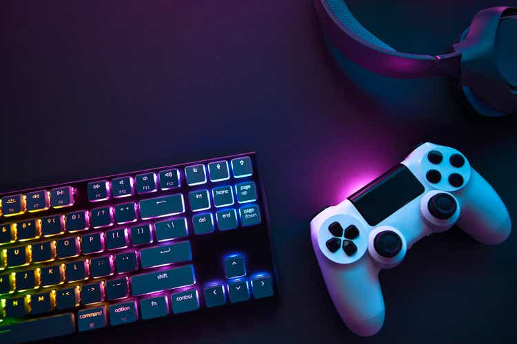 Top down view of colorful illuminated gaming accessories laying on table.