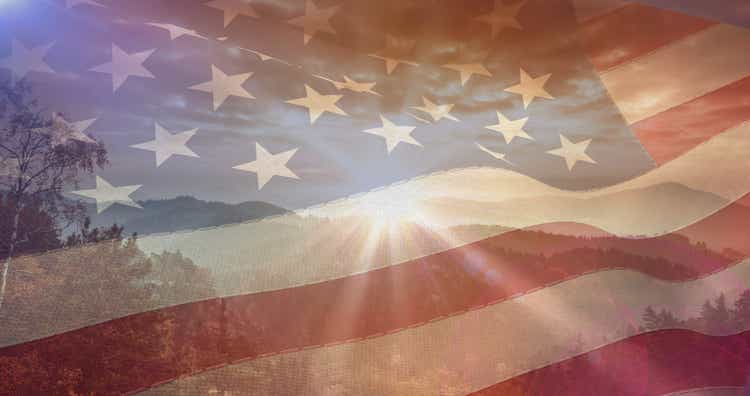 Composition of mountains, sky and sun over american flag