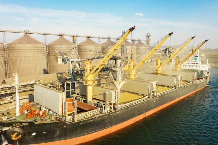 Loading grain into holds of sea cargo vessel through an automatic line in seaport from silos of grain storage. Bunkering of dry cargo ship with grain