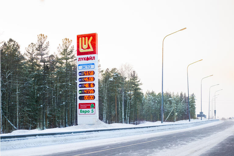 Information board of Lukoil gas station on the road, winter fuel prices