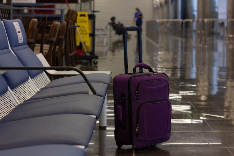 Unattended small carry on lugagge by empty bench seats at airport terminal