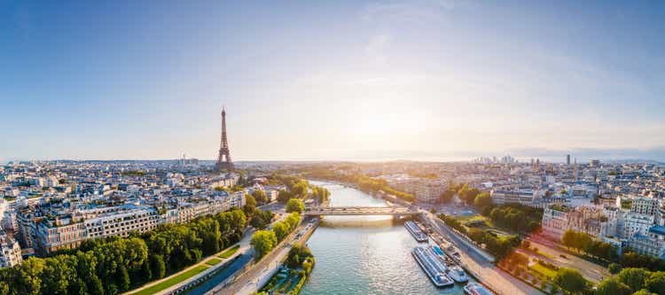 Paris aerial panorama with river Seine and Eiffel tower, France. Romantic summer holidays vacation destination. Panoramic view above historical Parisian buildings and landmarks with blue sky and sun