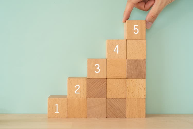 Step up; Wooden blocks with numbers and a hand.