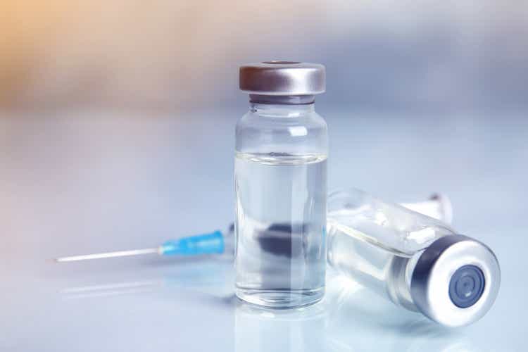 Fläschchen und Spritze auf Leuchttisch. Impfung und Immunisierung