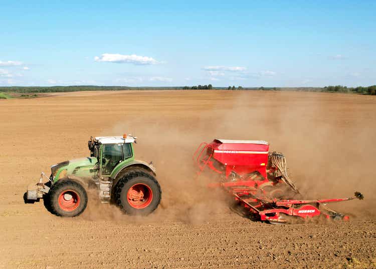 Agricultural tractor FENDT 930 Vario with seed wagon HORSCH on cultivating field for sowing seeds