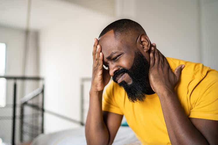 Man waking up with headache at home