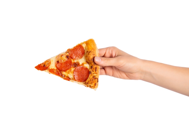 Fatia de pizza de pepperoni na mão isolada em branco. Vista de cima na pizza paperoni. Conceito de comida italiana, comida de rua, fast food, mordida rápida.