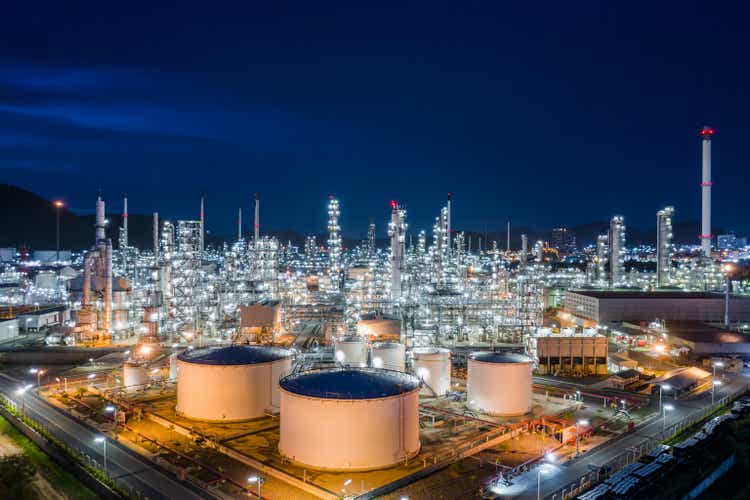 manufacturing and storage facilities oil and gas refineries products for sales and export international shipping frighted transportation open sea aerial view at night over lighting with blue sky background