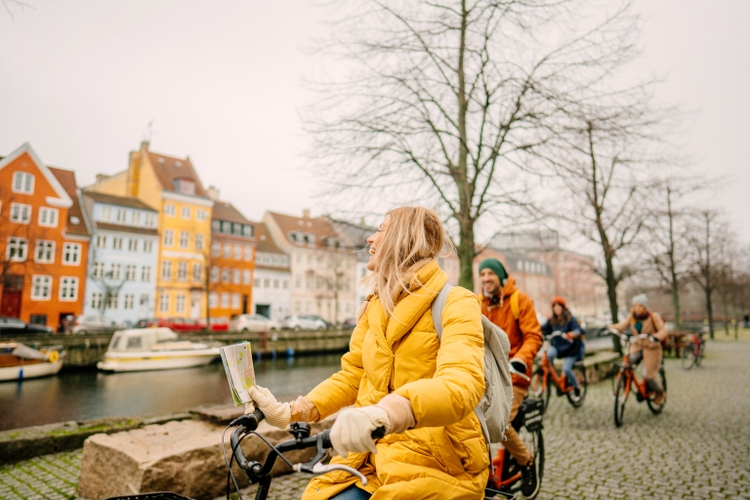 Travel guide and her group on the bicycles through the town