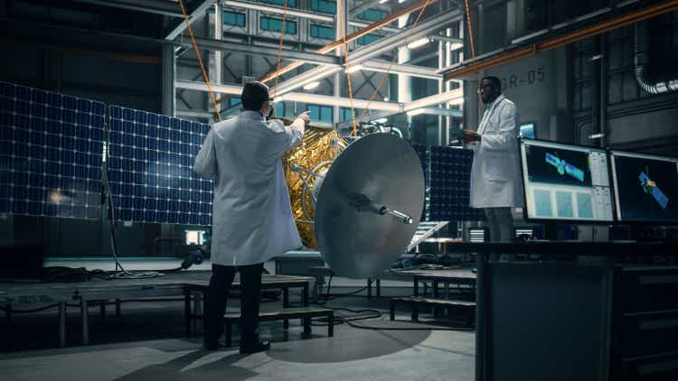 Engineer and Technician Working on Satellite Construction. Aerospace Agency: Diverse Team of Scientists Using Technological Equipment and Tablet Computer to Develop Spacecraft for Space Exploration.