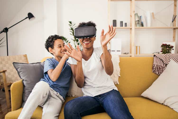 Madre e hijo usando un casco de realidad virtual y divirtiéndose
