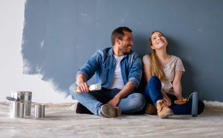 Loving couple having fun renovating their house and painting the walls