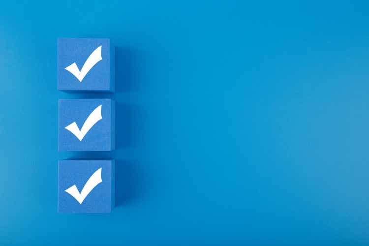 Three checkmarks on blue cubes against blue background with copy space