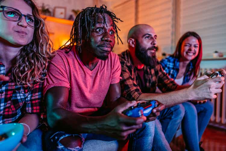Group of friends having fun playing video games at home