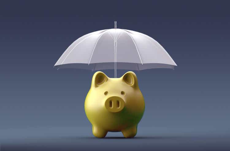 Umbrella is protecting a piggy bank on blue background.