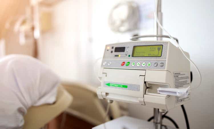 closeup adjust infusion pump set iv fluid intravenous drop saline drip on white background in a hospital.