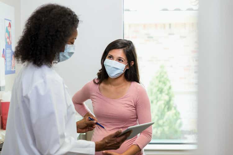 Doctor and patient wear masks to slow spread of illness