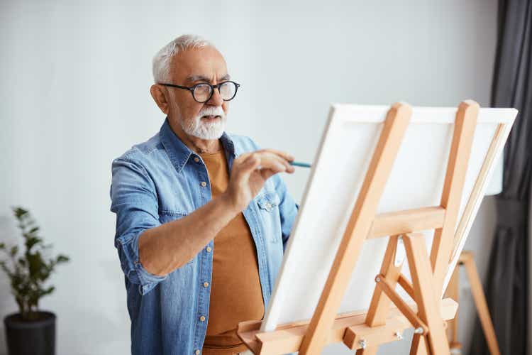 Senior Künstler malt auf Leinwand in seinem Heimatelier.
