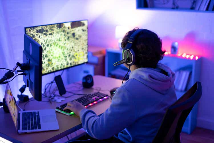 Teenager gaming online in his bedroom