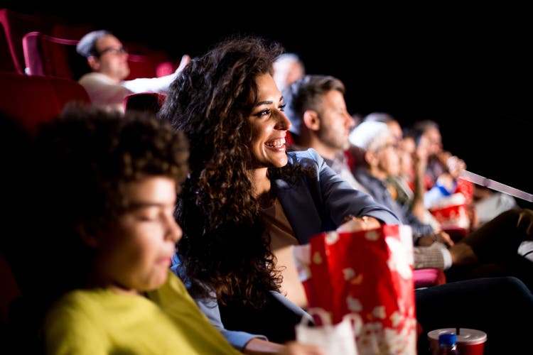Happy woman enjoying with her boy at the cinema