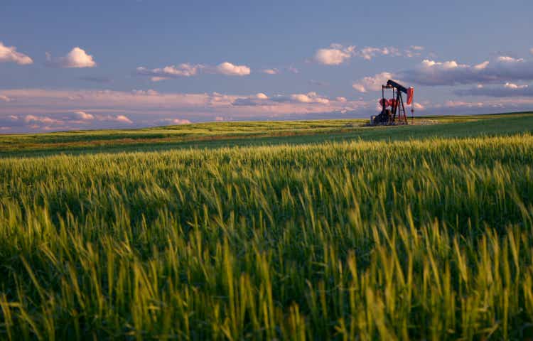 Red Pumpjack in Wheat Field on the Rolling Alberta Plains
