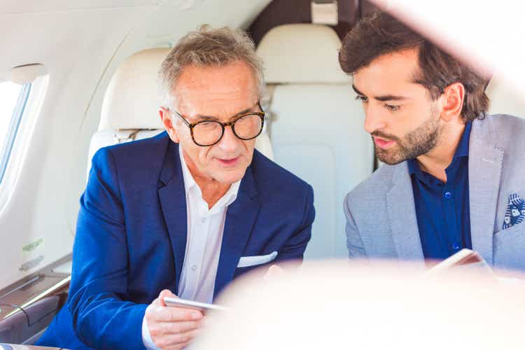 Two businessmen traveling by corporate jet
