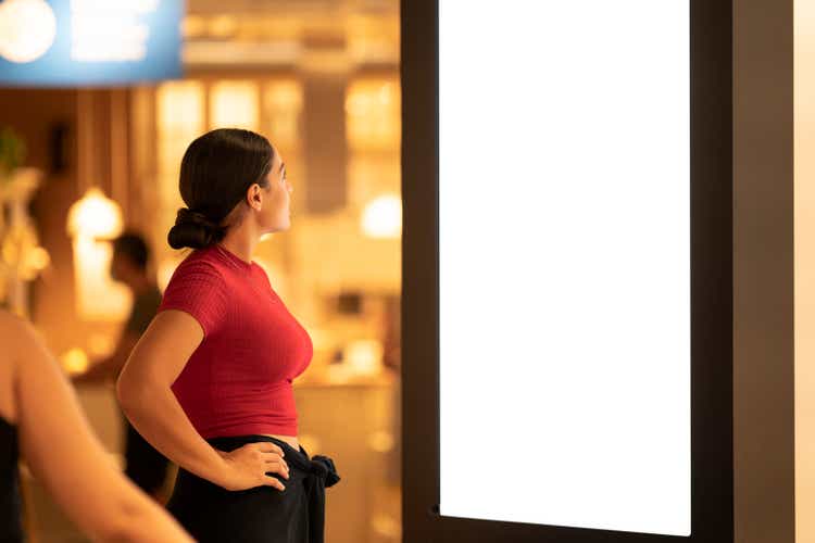 A young woman is shopping for a house in a furniture store.