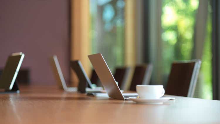 Laptop computer stand on wooden meeting table